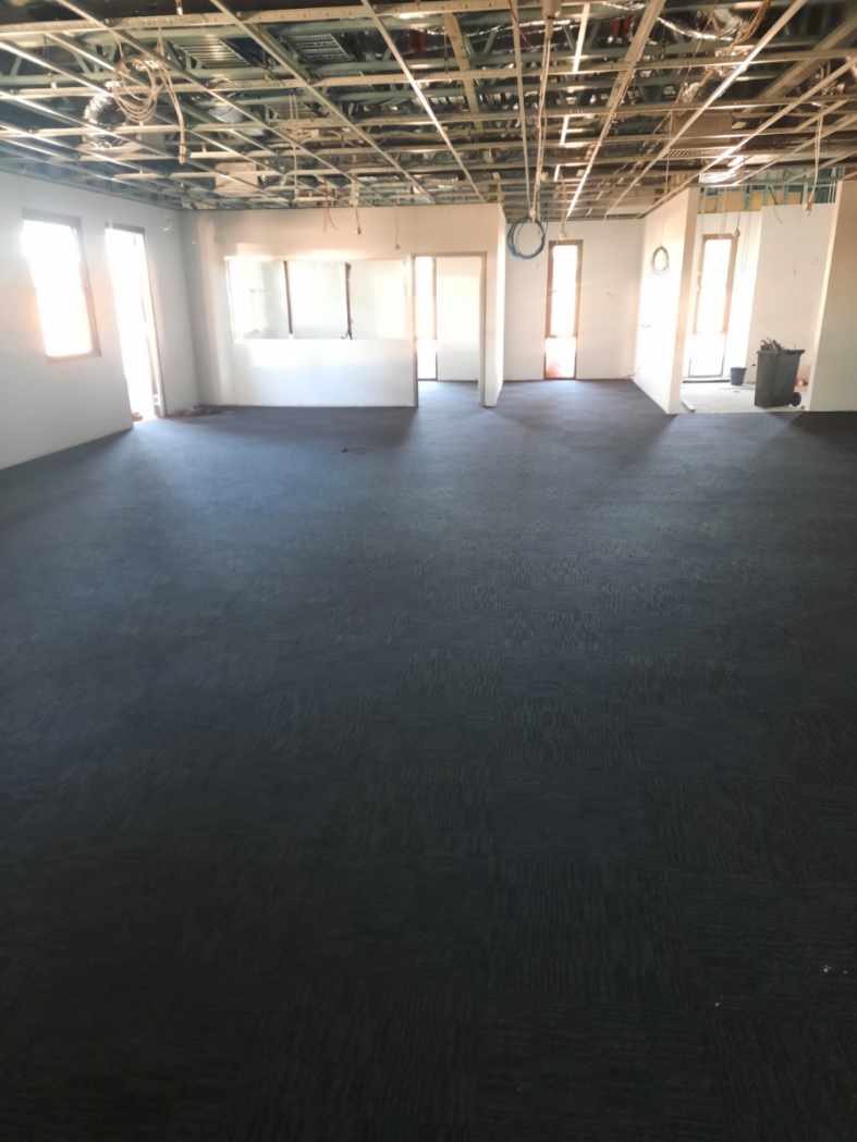 Dark charcoal carpet installed across the large main open-plan area of the fire station — Grafton